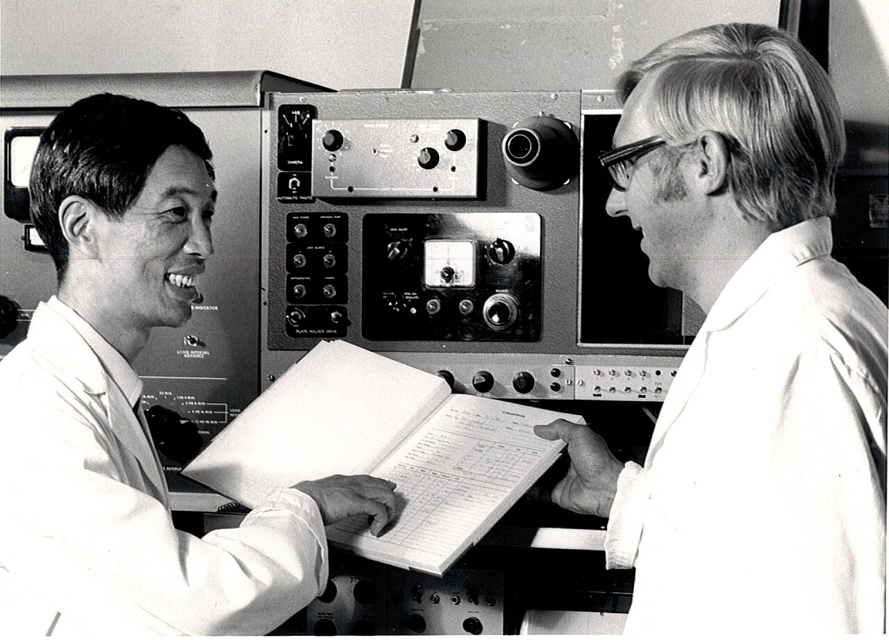 Two researchers reviewing and discussing experimental results in a laboratory.